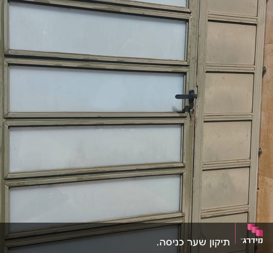 שער מתכת עם לוחות זכוכית בחצר